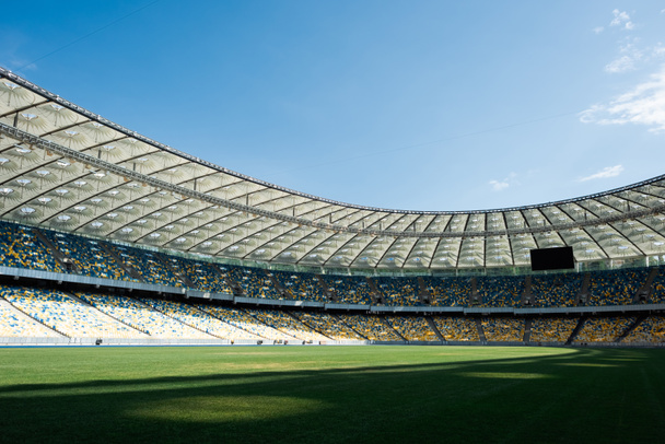 χορταριασμένο γήπεδο ποδοσφαίρου στο γήπεδο την ηλιόλουστη μέρα με μπλε ουρανό - Φωτογραφία, εικόνα