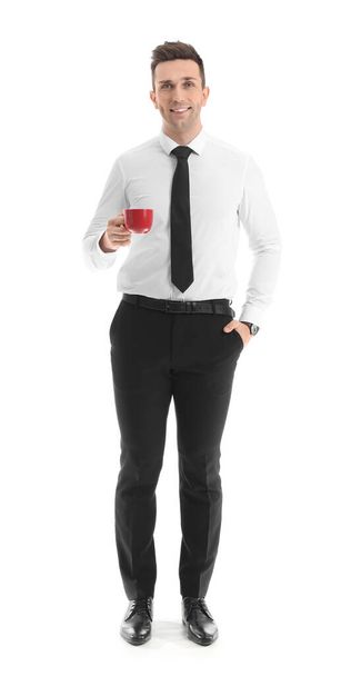 Handsome businessman drinking coffee on white background - 写真・画像