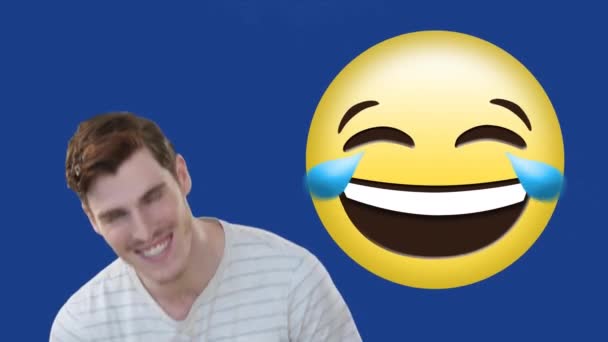 Animation of a Caucasian man laughing with a laughing emoji on blue background. Global economy and technology concept digital composite - Záběry, video