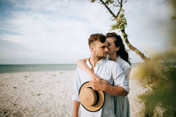 Διακοπές στη θάλασσα νέων ανθρώπων. Νεαρό ζευγάρι αγκαλιάζεται στην παραλία - Φωτογραφία, εικόνα