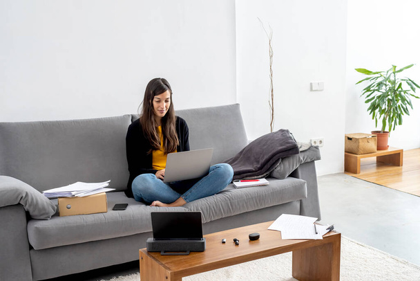 Junge Frau mit Laptop auf dem Sofa zu Hause - Foto, Bild
