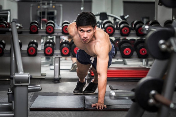 Bonito atraente asiático homens treino empurrar para cima no ginásio para se concentrar na sensação muscular tão forte e motivação para a construção do corpo, conceito halterofilista
 - Foto, Imagem