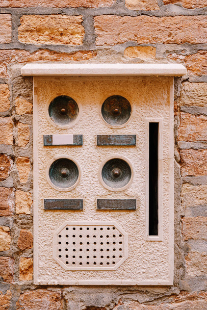 Close-ups of building facades in Venice, Italy. An old vintage intercom and a mailbox on a stone wall. On door where placed this old rusty doorbells. - Photo, Image