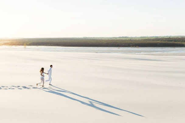 Wedding Newlyweds run barefoot through the White Desert. - Foto, immagini