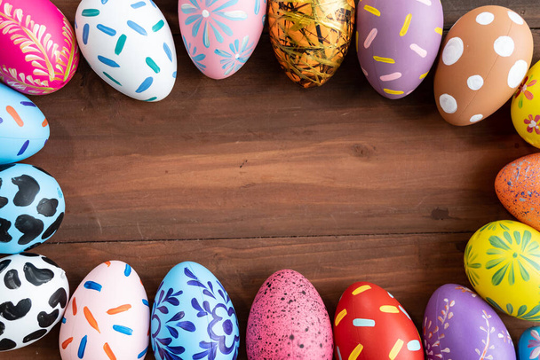 Velikonoční vajíčka na dřevěném pozadí s kopírovacím prostorem, barevné a ručně malované na vajíčka na Velikonoční den tradiční v Evropě, koncepce Velikonočního dne - Fotografie, Obrázek
