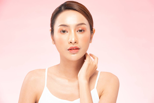 Beautiful Asian woman touching neck smile with clean and fresh skin Happiness and cheerful with positive emotional,isolated on pink background,Beauty Cosmetics and spa Treatment Concept - Photo, Image