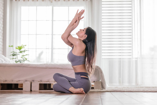 Attractive Asian woman practice yoga Eagle arms pose pose to meditation in bedroom after wake up in the morning Feeling so comfortable and relax,Healthcare Concept - Foto, imagen
