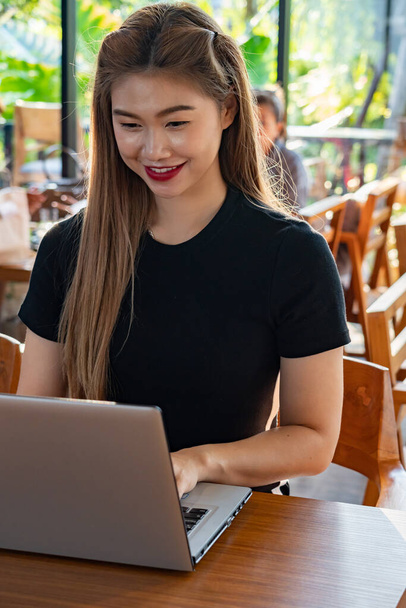 Bilgisayarlı dizüstü bilgisayarla çalışan Asyalı güzel bir kadın iş hayatında fikir ve gereksinim edinmeyi düşünüyor. - Fotoğraf, Görsel