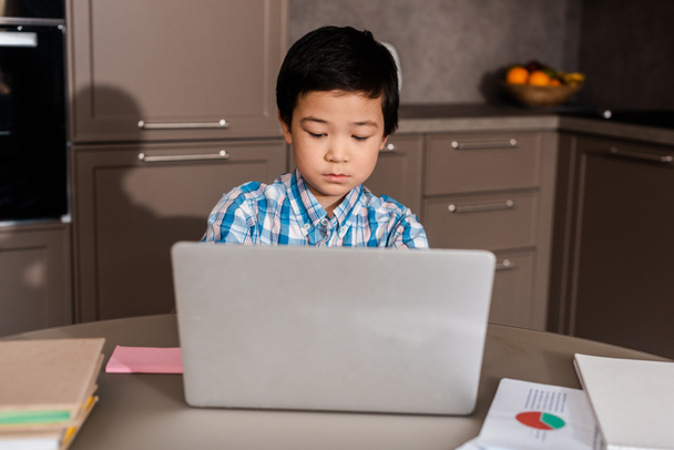 ασιατικό αγόρι σπουδάζει online με φορητό υπολογιστή στο σπίτι κατά τη διάρκεια της καραντίνας - Φωτογραφία, εικόνα