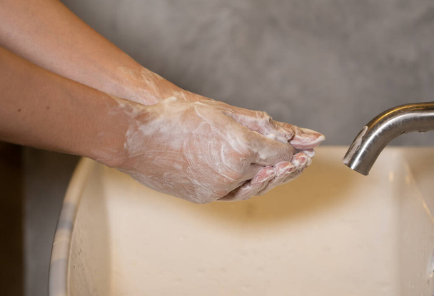 fechar as mãos no lavatório, lavar as mãos com desinfetante e lavar a mão espuma para limpeza e mão protegida de vírus e anti-bactérias
 - Foto, Imagem
