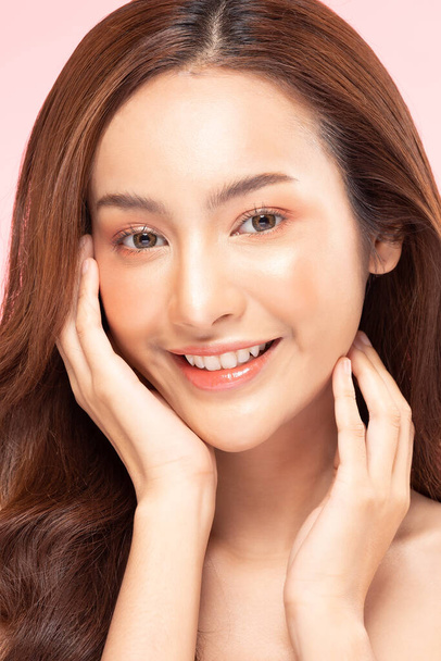 Beautiful Asian woman touching soft cheek smile with clean and fresh skin Happiness and cheerful with positive emotional,isolated on pink background,Beauty Cosmetics and spa Treatment Concept - Foto, afbeelding