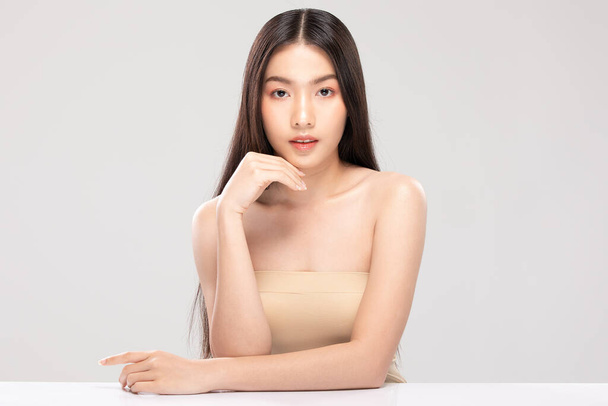 Beautiful Young Asian Woman Looking While Touching Chin feeling so happy and cheerful with healthy Clean and Fresh skin,isolated on white background,Beauty Cosmetics Concept - Zdjęcie, obraz