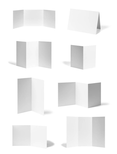 coleção de vários folheto dobrado em branco ou um calendário de desktop papel branco sobre fundo branco. cada um é baleado separadamente - Foto, Imagem