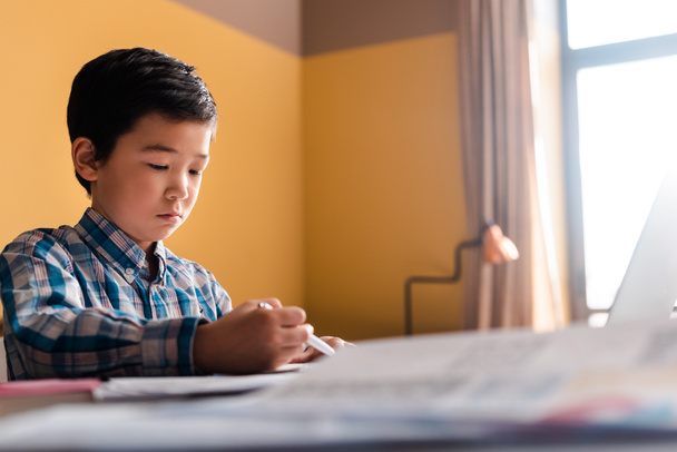 Azji chłopiec pisanie i nauka online z laptopem w domu podczas kwarantanny - Zdjęcie, obraz