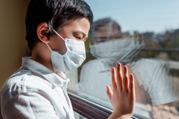 enfado asiático en máscara médica mirando a través de la ventana en cuarentena. - Foto, Imagen