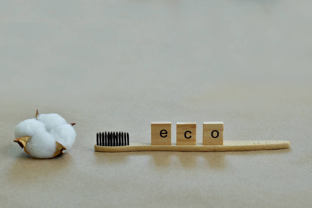 Cepillo de dientes de bambú ecológico y flor de algodón.Carta de madera ECO. Fondo de papel. Cero desperdicios, vida sin plástico. Concepto de ecología. Salvar el mundo.Enfoque selectivo
 - Foto, Imagen