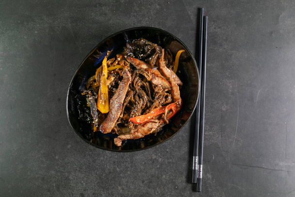 Fideos asiáticos con carne en plato
 - Foto, imagen