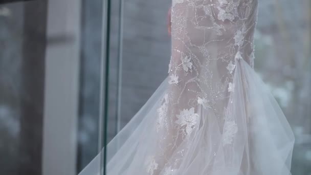 nevěsta pózuje v těsných svatebních šatech s elegantní výšivkou - Záběry, video