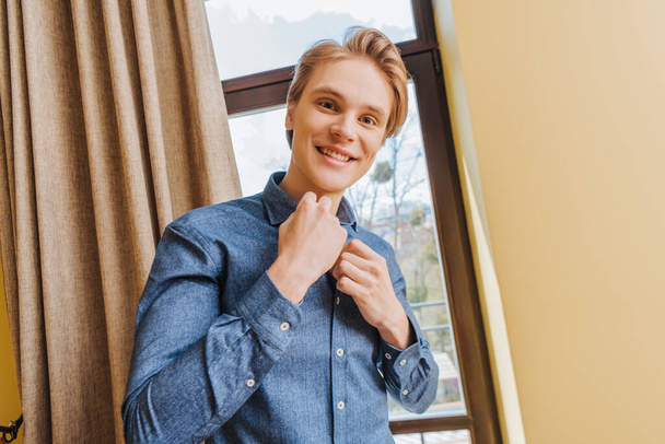 幸せな若い男が家で青いシャツに触れ隔離の概念の終わり - 写真・画像