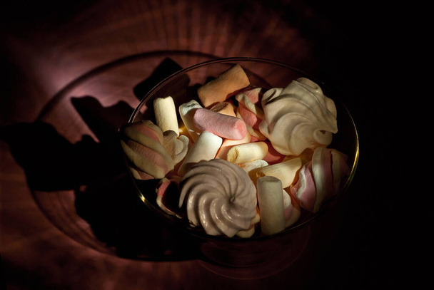 Sweets in a glass. Pink with white marshmallows on an orange background. - Valokuva, kuva