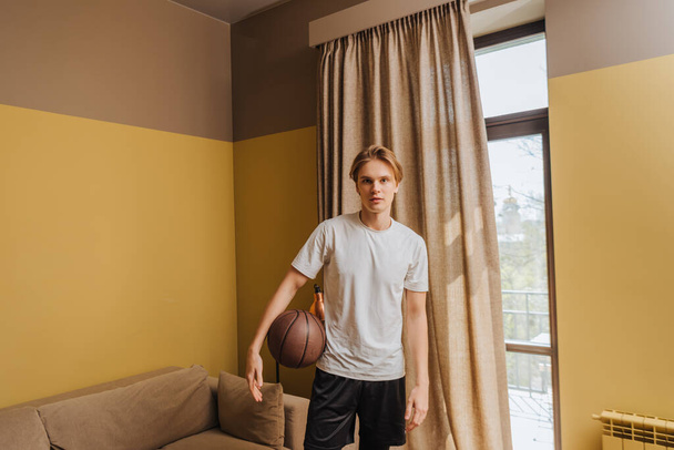 όμορφος άνδρας στέκεται με το μπάσκετ και κοιτάζοντας την κάμερα, τέλος της ιδέας καραντίνας - Φωτογραφία, εικόνα