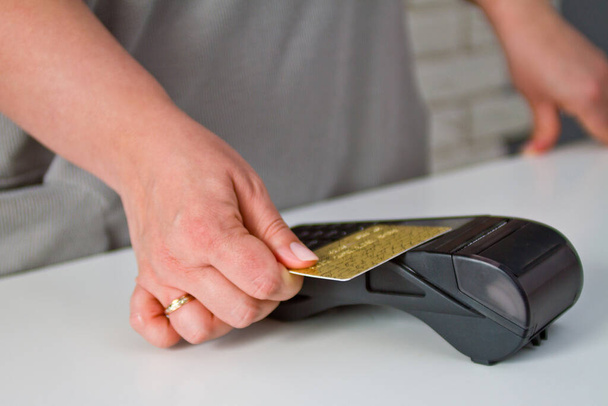 Detailní záběr ženy, která připojuje kartu k terminálu kreditní karty, aby zajistila platbu. Postup platby - Fotografie, Obrázek