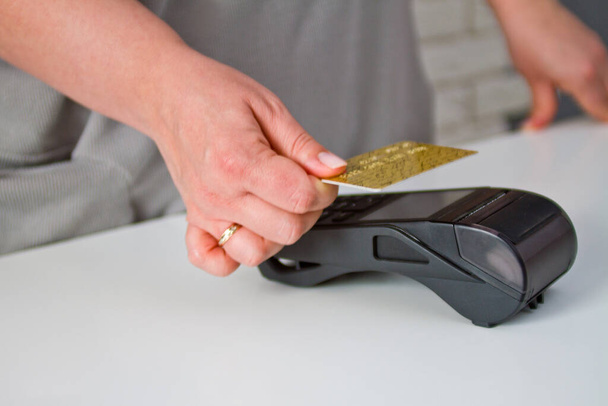 Detailní záběr ženy, která připojuje kartu k terminálu kreditní karty, aby zajistila platbu. Postup platby - Fotografie, Obrázek