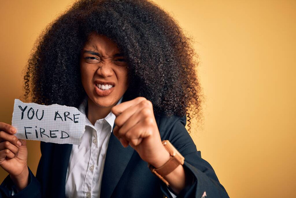 Африканский американский бизнес босс женщина с афро волосы держа вас уволены бумаги для увольнения раздражены и разочарованы кричать от гнева, сумасшедший и кричать с поднятой рукой, гнев концепции
 - Фото, изображение