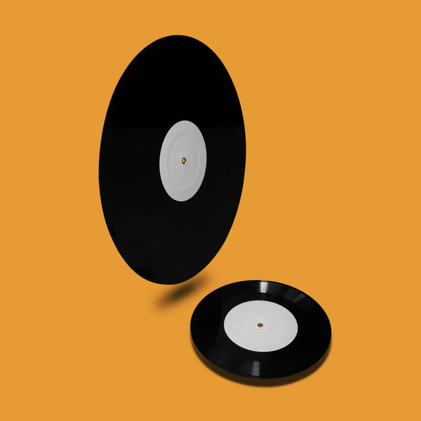 Fond vintage rétro abstrait de deux vinyles noirs avec des étiquettes blanches lévitant dans l'air et jetant l'ombre sur fond jaune avec espace de copie
 - Photo, image
