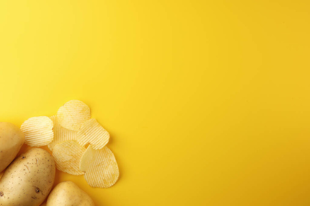 Τρεις πατάτες με τραγανά σνακ πατάτας σε κίτρινο φόντο. Εικόνα πάνω όψη, επίπεδη lay, και αντιγραφή χώρου. - Φωτογραφία, εικόνα