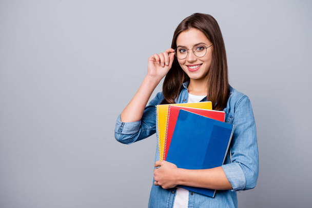 Close-up portrait of her she nice attractive lovely charming intelligent cheerful cheery girl holding in hands lesson exam test book materials isolated over grey pastel color background - Φωτογραφία, εικόνα
