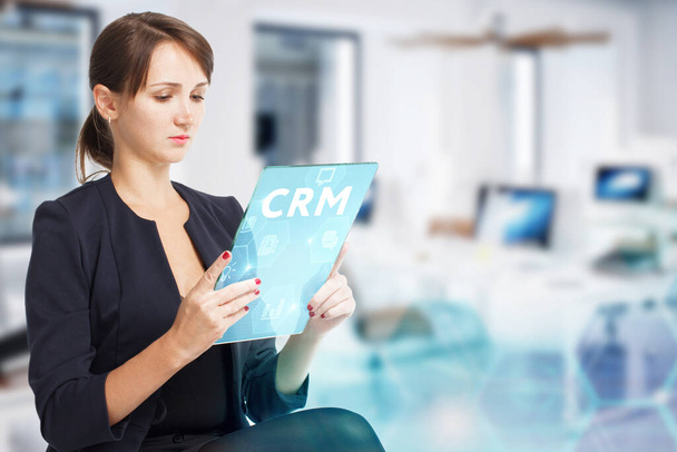 Business, Technology, Internet and network concept. Young businessman working on a virtual screen of the future and sees the inscription: CRM - Foto, afbeelding