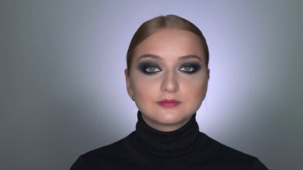 Kaunis nainen meikki savuinen silmät poseeraa kameran edessä - Materiaali, video