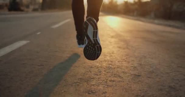 A lábakat közelről veszik. Reggeli futás. A nap fénye. Hideg idő. 4k - Felvétel, videó