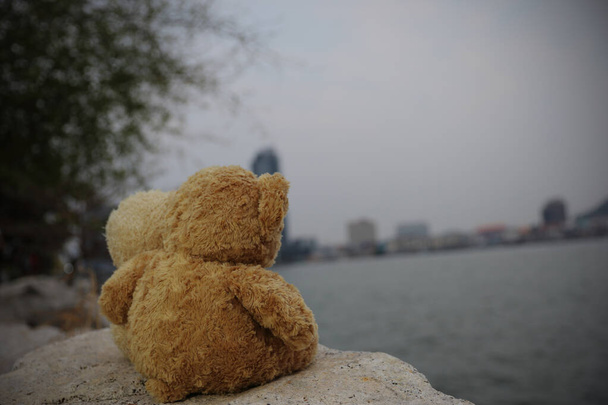 İki kahverengi oyuncak ayı kayanın üzerinde oturmuş şehri seyrediyor. Aşk kavramı, Sevgililer Günü. Resim biçimi eski antika. - Fotoğraf, Görsel