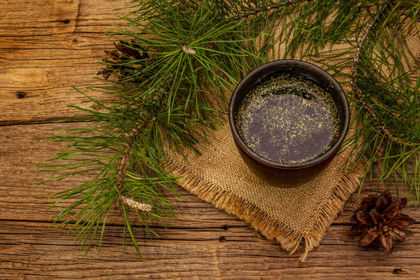Pine needle tea, sollip-cha, traditional Korean beverage. Alternative medicine, healthy life style. Vintage wooden boards background - Photo, Image