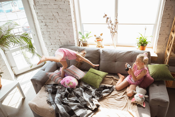 Quiet little girls playing in a bedroom in cute pajamas, home style and comfort, taking a photo - Valokuva, kuva