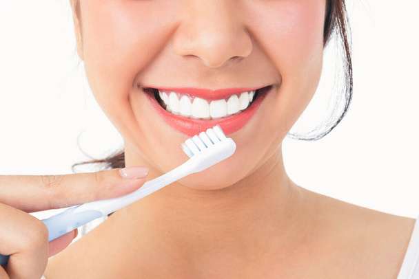 Piękna uśmiechnięta kobieta, czyste białe zęby, różowe usta, trzymać szczoteczkę do zębów. Koncepcja opieki ustnej. Białe tło - Zdjęcie, obraz