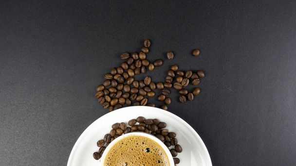 coffee love, coffee beans, latte art with bubbles in a black cup on a black background - Photo, Image
