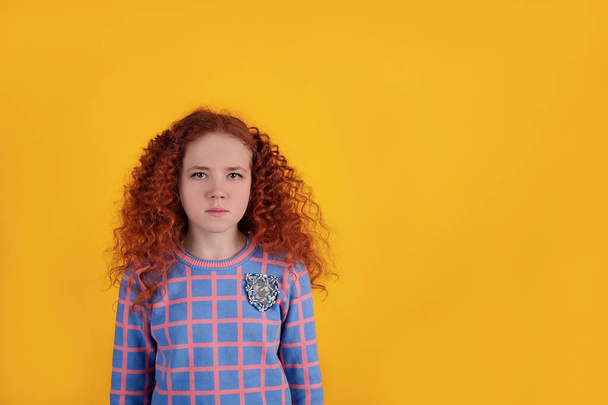 Gyönyörű vörös hajú lány, sárga háttérrel - Fotó, kép