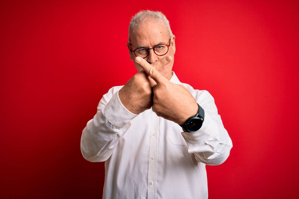Moyen âge beau homme satirique portant chemise décontractée et lunettes sur fond rouge expression de rejet croisement des doigts faire signe négatif
 - Photo, image