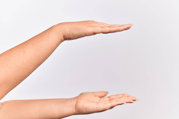 Käsi valkoihoinen nuori nainen tilalla kopio tilaa niiden välillä, mittaus molemmilla kämmenillä - Valokuva, kuva