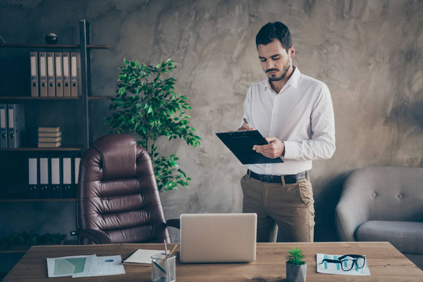 Portrait of his he nice attractive focused man skilled sales manager banker economist writing plan document at modern loft industrial style interior work place station indoors - Foto, Imagem
