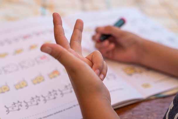 Parmak sayarken çocuğun eli matematik yapıyor. Ödev yapıyor. Saymayı öğreniyor. - Fotoğraf, Görsel