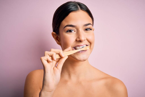 若い美しいブルネット女性ブラッシング彼女の歯ブラシと口腔ペーストを使用して、歯と舌をきれいに健康的な医療として朝のルーチン - 写真・画像