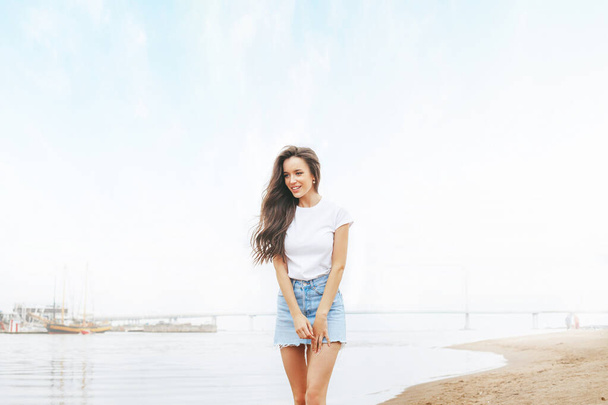 Young beautiful happy woman walks on beach in marina. Positive, travel, freedom. Europe - Foto, Imagen