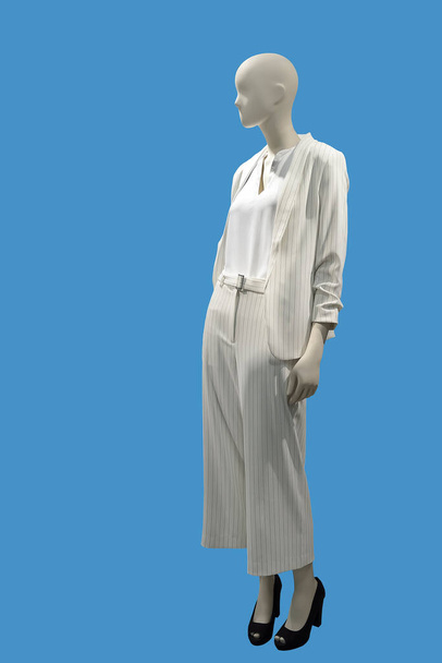 Manequim feminino de comprimento total vestido com terno de calça branca elegante isolado em fundo azul. Sem marcas ou objetos de direitos autorais
. - Foto, Imagem