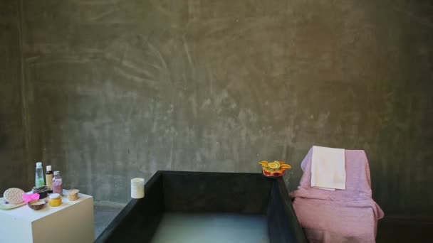 pretty young blond slim girl starts to throw rose petals into deep black bath - Footage, Video