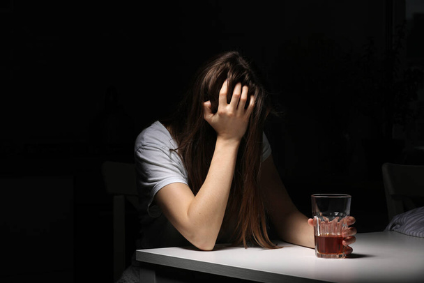 Blisko kobiety siedzącej i trzymającej szklankę whisky lub koniaku uzależnionej od alkoholu, przygnębionej kobiety pijącej mocny alkohol cierpiącej na problemy osobiste - Zdjęcie, obraz