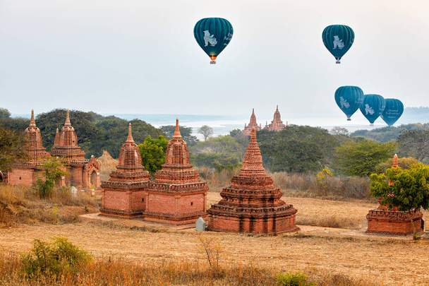 Hot air balloons with tourists fly over stupas in Old Bagan, Myanmar. - Photo, Image